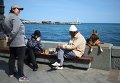 Отдыхающие играют в шахматы на набережной в Ялте Отдыхающие играют в шахматы на набережной в Ялте