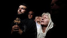 Верующие во время схождения Благодатного огня в храме Гроба Господня в Иерусалиме Верующие во время схождения Благодатного огня в храме Гроба Господня в Иерусалиме