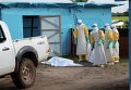 Медицинские работники возле изолятора для зараженных вирусом Эбола в Либерии Медицинские работники возле изолятора для зараженных вирусом Эбола в Либерии
