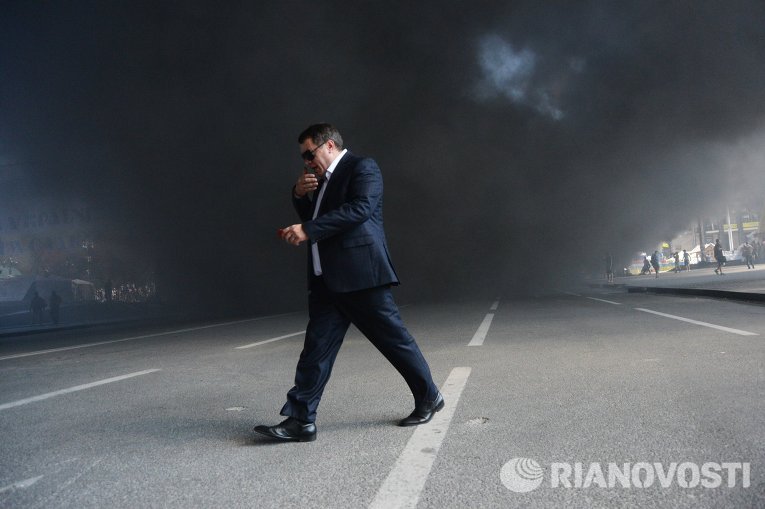 Мужчина идет мимо подожженных покрышек на площади Независимости в Киеве Мужчина идет мимо подожженных покрышек на площади Независимости в Киеве