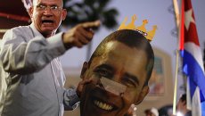 Протестующий с изображением президента США Барака Обамы во время акции протеста в Майами Протестующий с изображением президента США Барака Обамы во время акции протеста в Майами