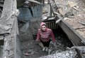 Женщина осматривает разрушенный дом после обстрела Донецка Женщина осматривает разрушенный дом после обстрела Донецка