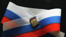 Ленточка и партийный значок Единой России. Архивное фото Ленточка и партийный значок Единой России. Архивное фото