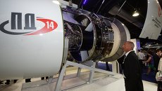 Посетитель у авиационного двигателя ПД-14. Архивное фото Посетитель у авиационного двигателя ПД-14. Архивное фото
