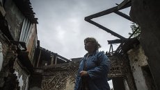 Ольга Бубнова во дворе своего дома, который был разрушен в результате попадания снаряда, в Донецке Ольга Бубнова во дворе своего дома, который был разрушен в результате попадания снаряда, в Донецке