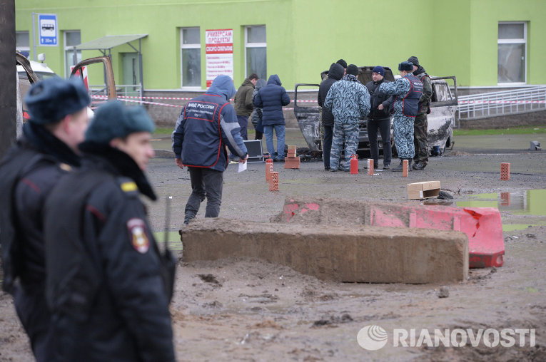 Представители правоохранительных органов осматривают место происшествия с полицейской машиной Представители правоохранительных органов осматривают место происшествия с полицейской машиной
