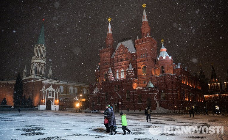 Прохожие во время снегопада на Красной площади в Москве Прохожие во время снегопада на Красной площади в Москве