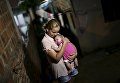 Мать держит свою больную микроцефалией дочь в Ресифи, Бразилия Мать держит свою больную микроцефалией дочь в Ресифи, Бразилия
