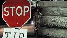 Украинский активист стоит на блокпосту возле Львова, блокируя движение грузовиков с российскими номерами во Львовской области. Архивное фото Украинский активист стоит на блокпосту возле Львова, блокируя движение грузовиков с российскими номерами во Львовской области. Архивное фото