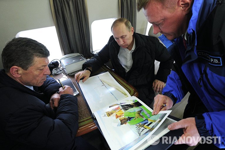 Президент России Владимир Путин (в центре) во время облета транспортного перехода через Керченский пролив. Слева - заместитель председателя правительства РФ Дмитрий Козак Президент России Владимир Путин (в центре) во время облета транспортного перехода через Керченский пролив. Слева - заместитель председателя правительства РФ Дмитрий Козак