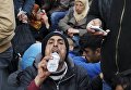 Мигрант пьет воду во время ожидания на греко-македонской границе Мигрант пьет воду во время ожидания на греко-македонской границе