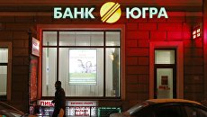 Прохожий у офиса Банка Югра в Санкт-Петербурге. Архивное фото Прохожий у офиса Банка Югра в Санкт-Петербурге. Архивное фото
