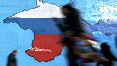 Прохожие у нарисованной на стене карты Крыма в цветах российского флага в Москве Прохожие у нарисованной на стене карты Крыма в цветах российского флага в Москве