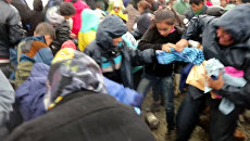 Беженцы дрались и выхватывали друг у друга гумпомощь в лагере возле Идомени Беженцы дрались и выхватывали друг у друга гумпомощь в лагере возле Идомени