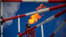 Газовый факел морской нефтеперерабатывающей платформы. Архивное фото Газовый факел морской нефтеперерабатывающей платформы. Архивное фото