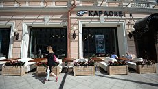 Прохожая у летней веранды на реконструированной Тверской улице в Москве. Архивное фото Прохожая у летней веранды на реконструированной Тверской улице в Москве. Архивное фото