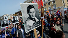 Участники акции Бессмертный полк во время шествия по улицам Владивостока Участники акции Бессмертный полк во время шествия по улицам Владивостока