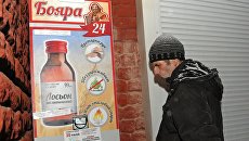 Мужчина у автомата по продаже спиртосодержащего средства с боярышником. Архивное фото Мужчина у автомата по продаже спиртосодержащего средства с боярышником. Архивное фото