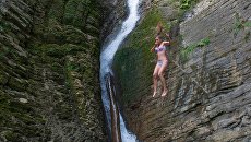 Девушка у Ореховского водопада в Сочинском национальном парке. Архивное фото Девушка у Ореховского водопада в Сочинском национальном парке. Архивное фото