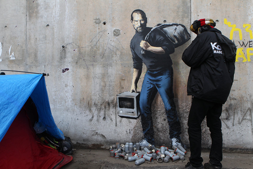 Граффити с изображением Стива Джобса художника Бэнкси на стене лагеря для беженцев в Кале, Франция.