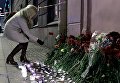 Женщина возлагает цветы рядом со станцией метро Технологический институт в память о погибших в результате взрыва в метро Санкт-Петербурга Женщина возлагает цветы рядом со станцией метро Технологический институт в память о погибших в результате взрыва в метро Санкт-Петербурга