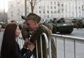 Военнослужащий с девушкой во время прохода военной техники по Тверской улице перед репетицией парада Победы на Красной площади Военнослужащий с девушкой во время прохода военной техники по Тверской улице перед репетицией парада Победы на Красной площади