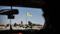 Флаг сил самообороны сирийских курдов (YPG) в провинции Ракка недалеко от границы с Турцией. Архивное фото Флаг сил самообороны сирийских курдов (YPG) в провинции Ракка недалеко от границы с Турцией. Архивное фото