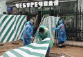 Строители поднимают сорванный ураганом заградительный забор на улице Остоженка в Москве Строители поднимают сорванный ураганом заградительный забор на улице Остоженка в Москве