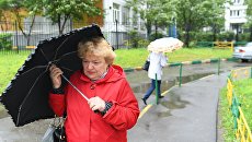 Прохожие во время дождя. Архивное фото Прохожие во время дождя. Архивное фото
