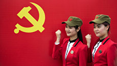 Девушки фотографируются с флагом Коммунистической партии Китая в Шаошане. Архивное фото Девушки фотографируются с флагом Коммунистической партии Китая в Шаошане. Архивное фото