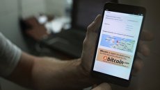 Демонстрация на смартфоне мобильного приложения для работы с криптовалютой биткоин в стационарном обменном пункте криптовалют в Москве. Архивное фото Демонстрация на смартфоне мобильного приложения для работы с криптовалютой биткоин в стационарном обменном пункте криптовалют в Москве. Архивное фото