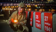 Участница патриотической акции Линия памяти зажигает свечу на Крымской набережной вдоль Москвы-реки в память о погибших в Великой Отечественной войне Участница патриотической акции Линия памяти зажигает свечу на Крымской набережной вдоль Москвы-реки в память о погибших в Великой Отечественной войне