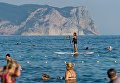 Девушка занимается SUP серфингом в акватории Яшмового пляжа у мыса Фиолент в Севастополе Девушка занимается SUP серфингом в акватории Яшмового пляжа у мыса Фиолент в Севастополе