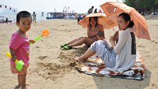 Жители города на пляже Харбина, Китай Жители города на пляже Харбина, Китай
