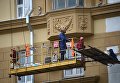 Рабочие у фасада здания на Смоленской площади Рабочие у фасада здания на Смоленской площади