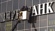 Рабочие завешивают вывеску. Архивное фото Рабочие завешивают вывеску. Архивное фото