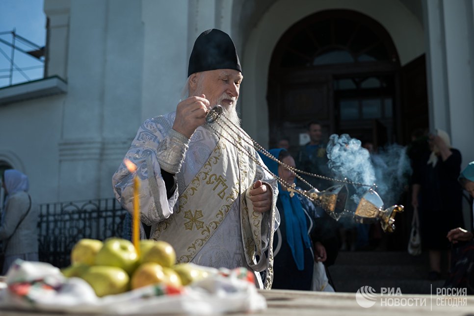 Священнослужитель и верующие во время богослужения в честь праздника Преображения Господня у собора Воздвижения Креста Господня в Омске. 19 августа 2017 Священнослужитель и верующие во время богослужения в честь праздника Преображения Господня у собора Воздвижения Креста Господня в Омске. 19 августа 2017