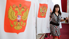 Девушка на избирательном участке. Архивное фото Девушка на избирательном участке. Архивное фото