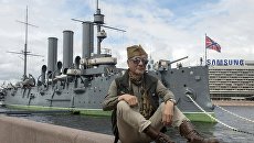 Мужчина на Петроградской набережной возле музея Крейсер Аврора в Санкт-Петербурге Мужчина на Петроградской набережной возле музея Крейсер Аврора в Санкт-Петербурге