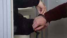 Сотрудник правоохранительных органов снимает наручники. Архивное фото Сотрудник правоохранительных органов снимает наручники. Архивное фото