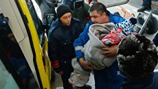 Сотрудник медицинской помощи переносит выжившую при крушении самолета L-410 девочку в автомобиль скорой помощи в Хабаровске. Архивное фото Сотрудник медицинской помощи переносит выжившую при крушении самолета L-410 девочку в автомобиль скорой помощи в Хабаровске. Архивное фото
