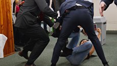 Охранники и нападавшая на действующего главу государства Милоша Земана на избирательном участке в Праге. 12 января 2018 Охранники и нападавшая на действующего главу государства Милоша Земана на избирательном участке в Праге. 12 января 2018