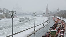 Автомобили на Кремлевской набережной в Москве во время снегопада Автомобили на Кремлевской набережной в Москве во время снегопада