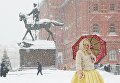 Женщина с зонтом на Манежной площади во время снегопада в Москв Женщина с зонтом на Манежной площади во время снегопада в Москв