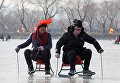 Туристы катаются на санках по льду озера Куньмин на окраине Пекина Туристы катаются на санках по льду озера Куньмин на окраине Пекина