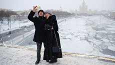 Люди фотографируются на арке Парящего моста парка Зарядье в Москве. Архивное фото Люди фотографируются на арке Парящего моста парка Зарядье в Москве. Архивное фото