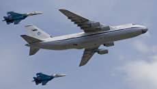 Стратегический военно-транспортный самолет Ан-124 Руслан в сопровождении двух истребителей Су-27. Архивное фото Стратегический военно-транспортный самолет Ан-124 Руслан в сопровождении двух истребителей Су-27. Архивное фото