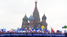 Участники первомайской демонстрации несут плакат Единство, солидарность, труд - гарантия успешного развития на Красной площади в Москве Участники первомайской демонстрации несут плакат Единство, солидарность, труд - гарантия успешного развития на Красной площади в Москве