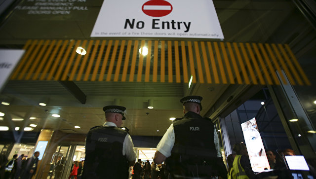 Сотрудники британской полиции у входа в терминал аэропорта в Лондоне. Архивное фото