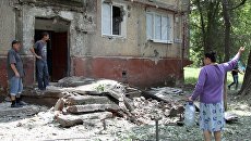 Жители во дворе жилого дома, пострадавшего в результате обстрела, в поселке Горловка Донецкой области. 21 мая 2018 Жители во дворе жилого дома, пострадавшего в результате обстрела, в поселке Горловка Донецкой области. 21 мая 2018
